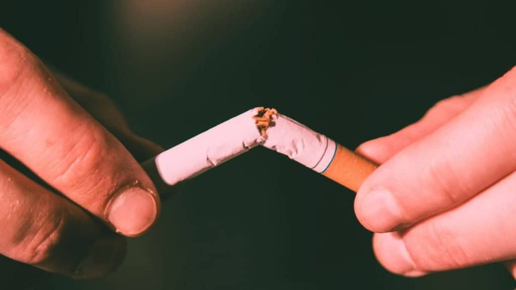 Close of of someone snapping a cigarette in two