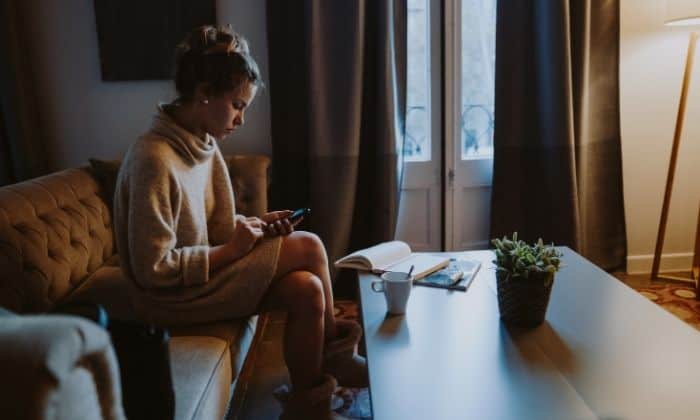 woman starting at phone upset with drunk texts trying to forgive herself