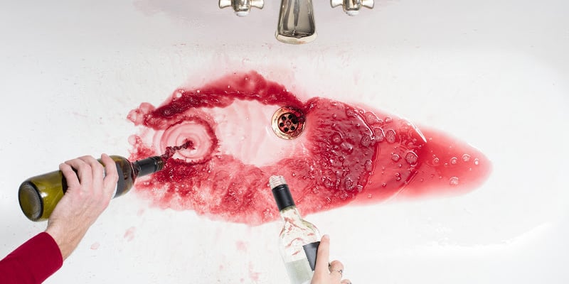 pouring out alcohol to get sober