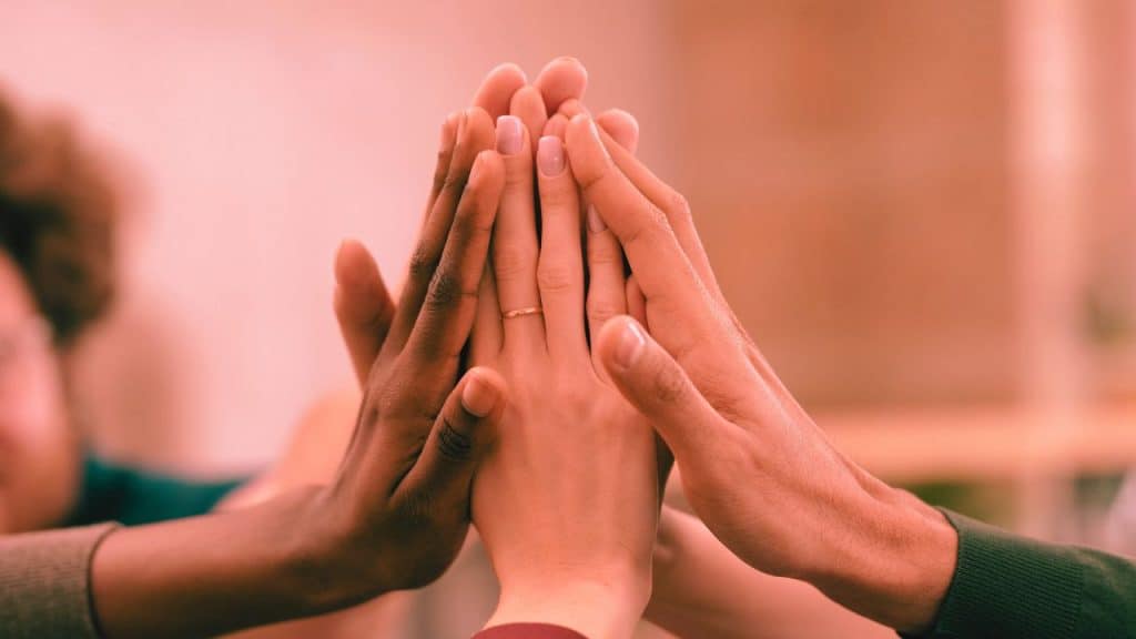 A group of hands form together in support