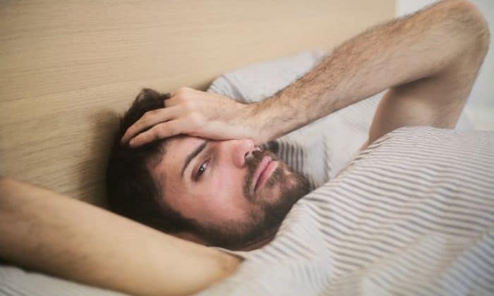 man suffering from hangxiety in bed