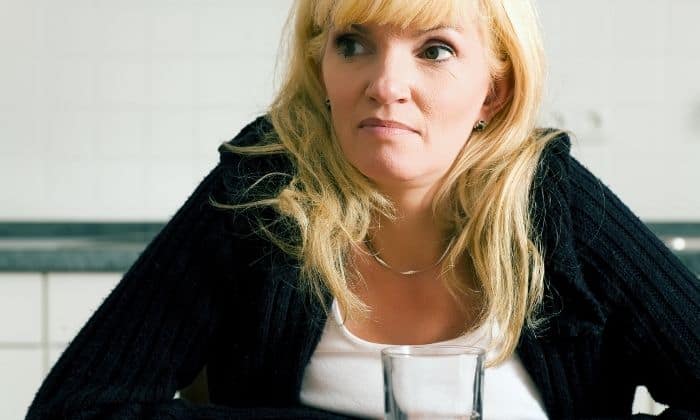 woman with glass of water suffering from anxiety hangover
