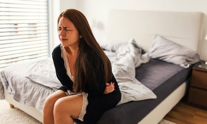woman clutching stomach after having diarrhea from alcohol