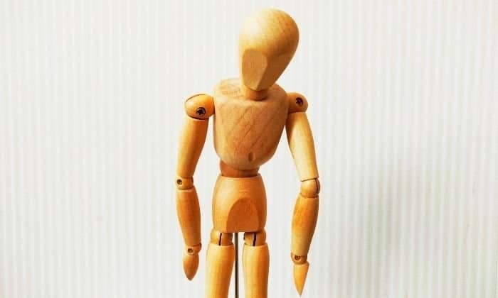 wooden figure slumped over in grief