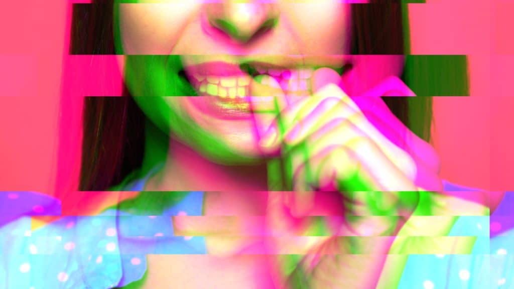A scrambled close up image of a woman with anxiety tics biting her nail