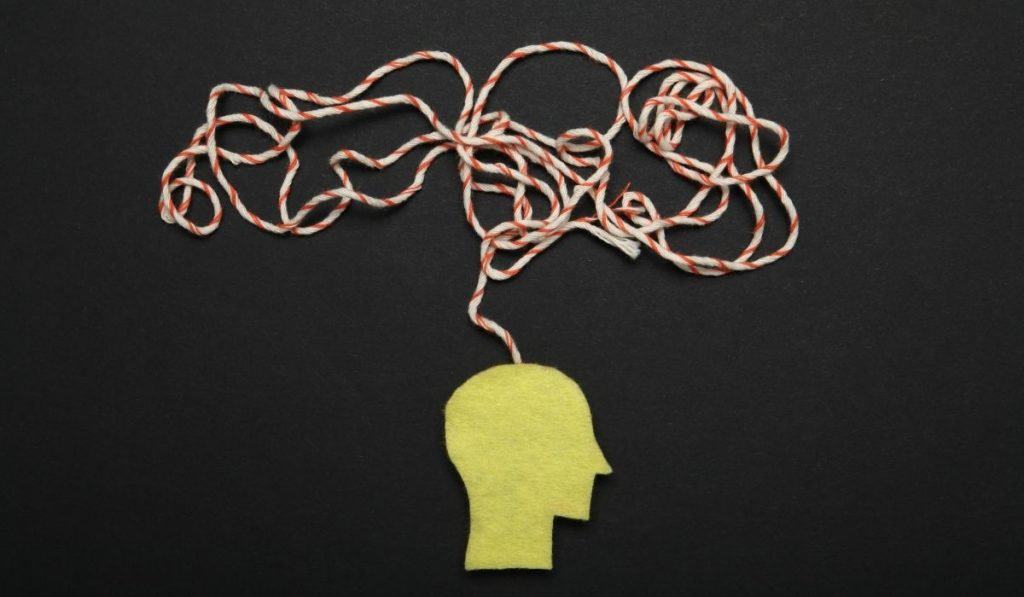 felt head profile with chaotic string representing a brain with anxiety