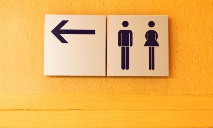 Public bathroom sign pointing to the left