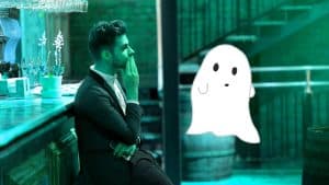 A man sits at a bar looking out. He's been ghosted and stood up. There is a graphic of a ghost in front of him.
