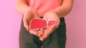 A woman holds an image of a liver delicately in her hands