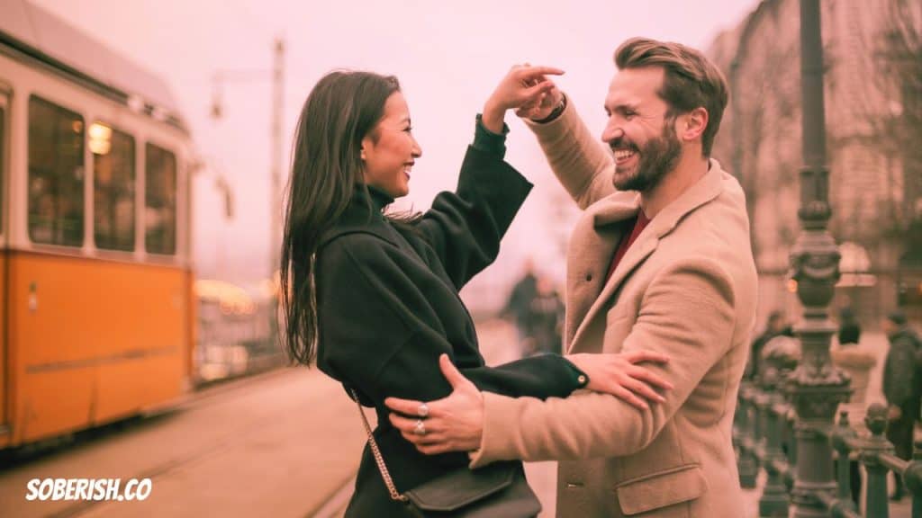 A couple dances in the street beside a street car
