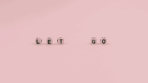 letter cubes set up to spell Let Go. This is a featured image for an article about shadow work prompts for letting go