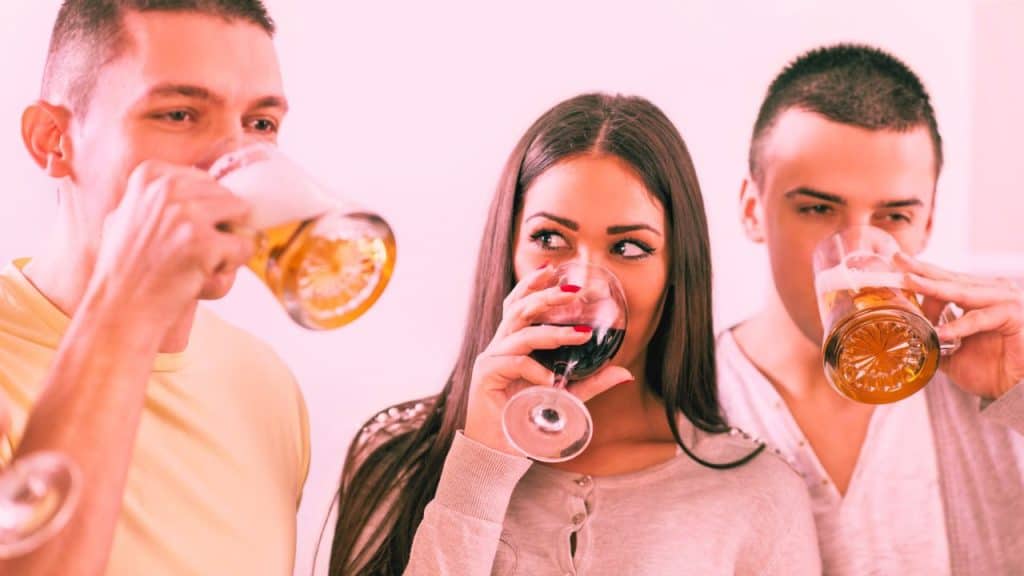 Two men and a woman drink alcohol unable to stop