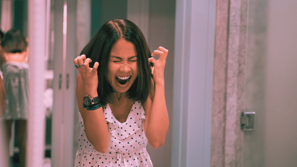 A woman clenches her fist and screams in anger, suffering from a major BPD outburst