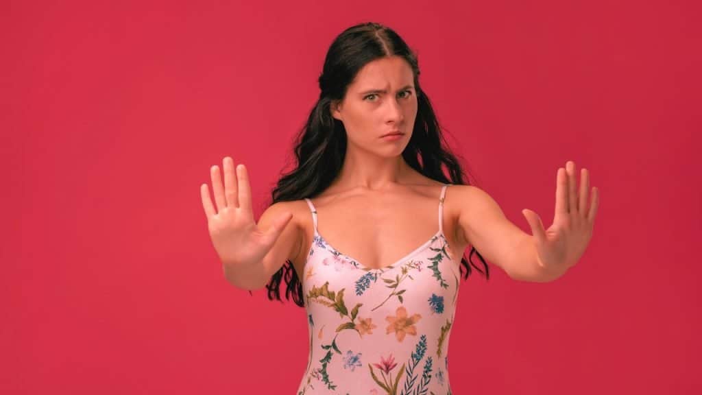 A woman holds up her hands in a gesture to stop