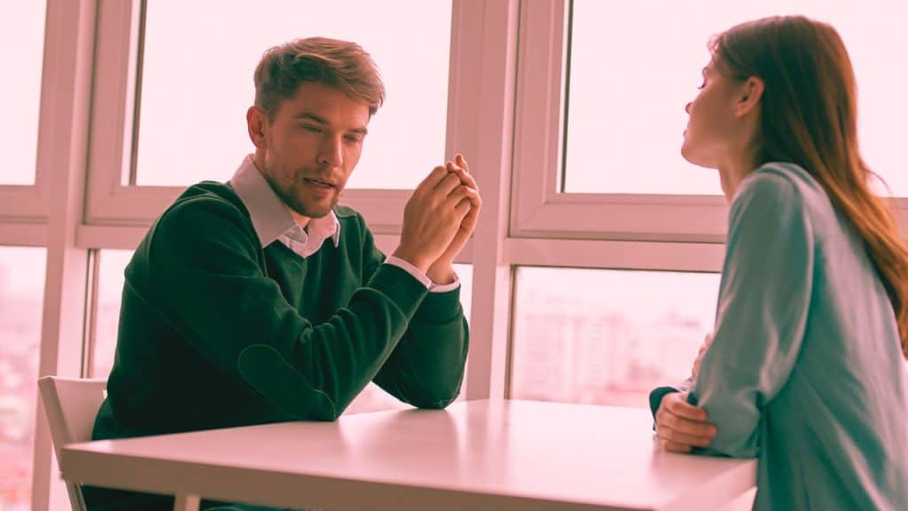A man confronts his gaslighting partner at a table