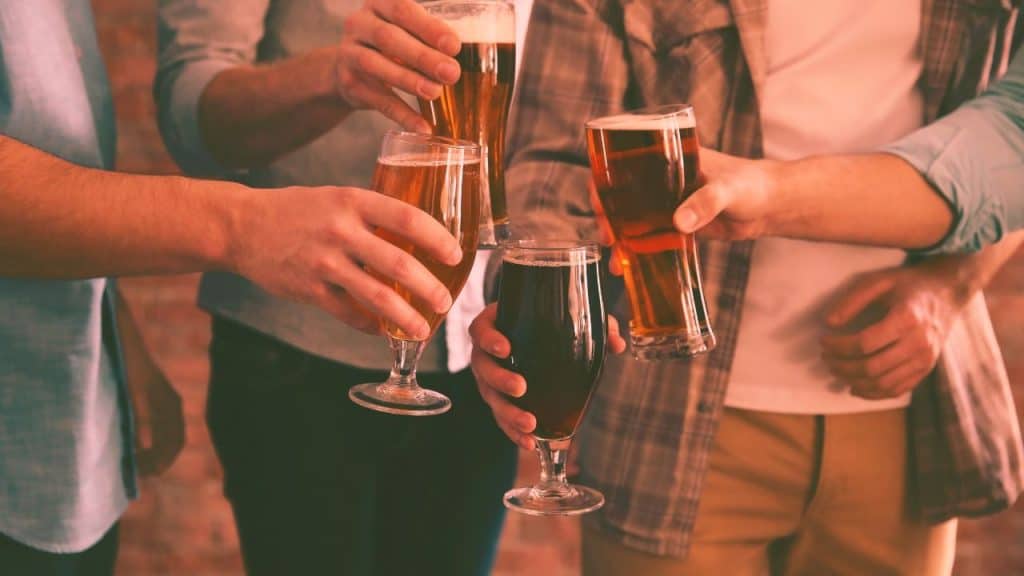 close ups of men clinking their beer glasses together