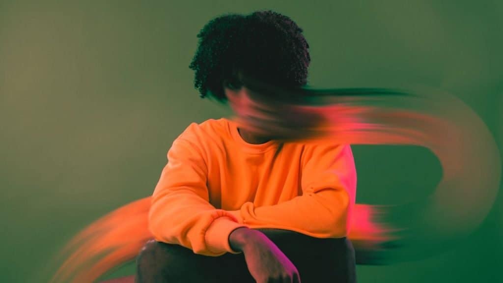 distorted image of a person sitting on the ground. the distortion represents anxiety