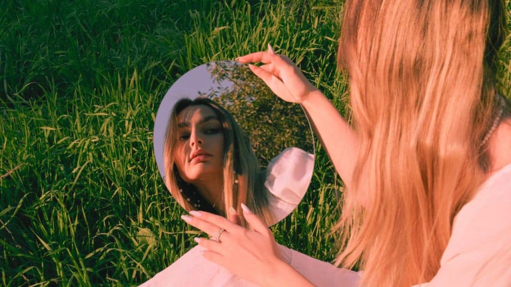 A woman with a distorted self-image stares at the mirror, unhappy with what she sees