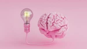 Pink brain connected to a lightbulb