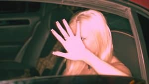 A woman with a distorted self-image shields her face from being seen