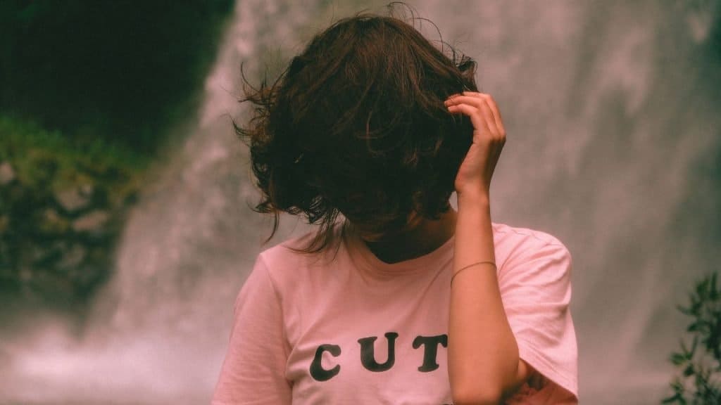A woman with negative core beliefs hides behind her hair