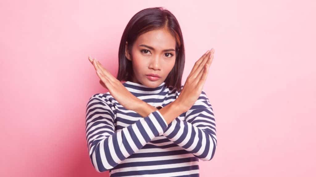 A woman crosses her arms in front of herself in defiance, setting boundaries