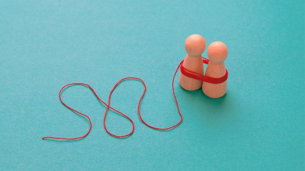 Two pegs tied up with a red string