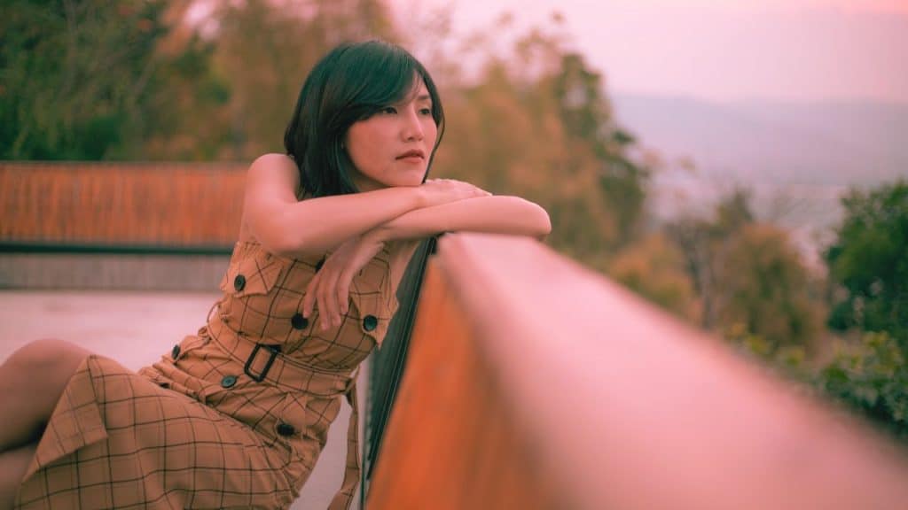 A woman who has recently been devalued in a BPD relationship stares over a bridge pensively
