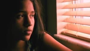 An insecure woman stares outside the window